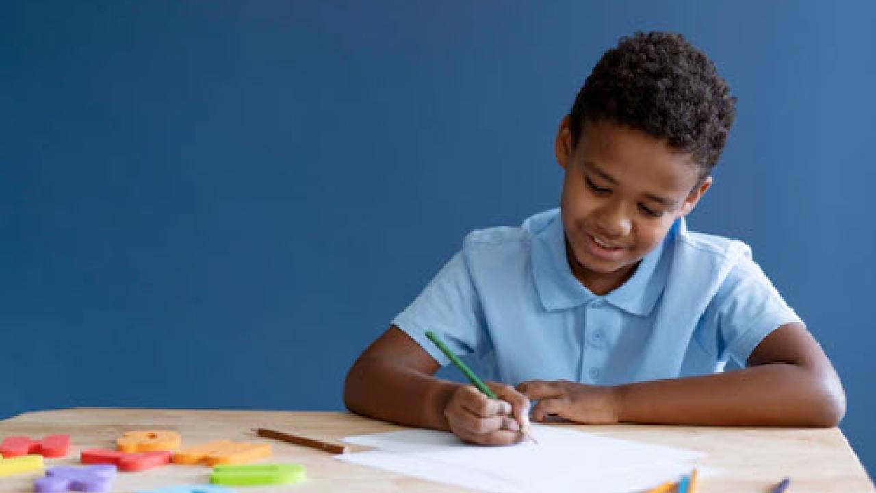 Young boy at desk drawing